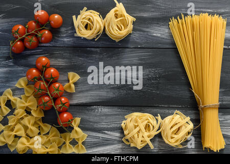 Pasta with tomatoes on wooden background Stock Photo