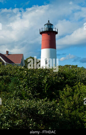 Nauset lighthouse with its striped tower like a candy cane on a summer day on Cape Cod with cumulus clouds above. Stock Photo