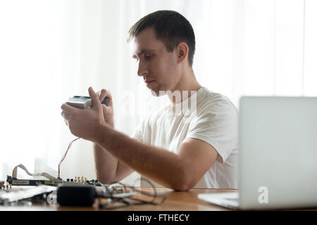 Portrait of handsome professional computer repairman repairing broken pc parts in the office Stock Photo