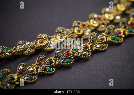 Metal necklace with colorful stones on black background Stock Photo