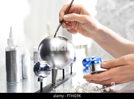 Painting Christmas balls. Manufacturing and crafts. Woman decorate baubles. Christmas tree decorations Stock Photo