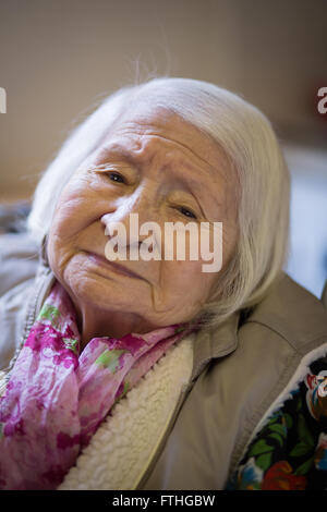 Elderly Chinese lady looking thoughtfully into the camera Stock Photo