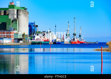 Ahus, Sweden - March 20, 2016: The harbor in Ahus is one of Southern Swedens most important bulk ports. Here seen from the canal Stock Photo