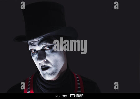 Portrait of dark angry mime wearing  tall hat Stock Photo