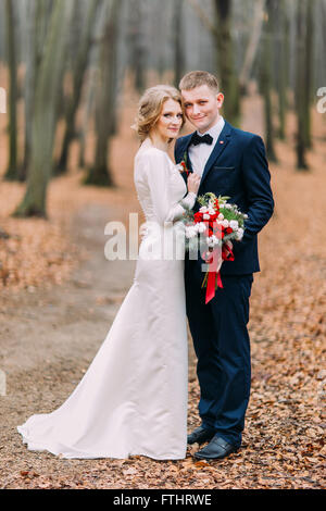 Beautiful wedding couple posing in the autumn forest Stock Photo