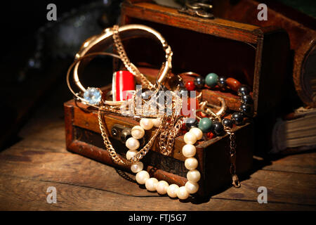 Closeup of open jewelry box on wooden background Stock Photo
