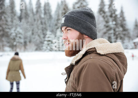 Portrait of a man looking away outdoors with snow on backgorund Stock Photo