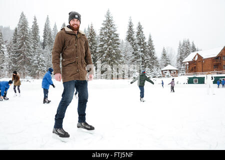 Portrait of a happy man ice skating outdoors Stock Photo