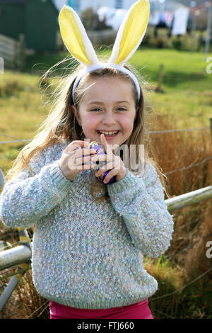Bunny ears on a seven year old girl whilst on an easter egg hunt Stock Photo