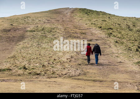 A couple walk along a path on the site of an ancient tumulus in Newquay, Cornwall. Stock Photo