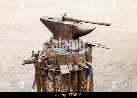 Old anvil with blacksmith tools at the outdoors Stock Photo