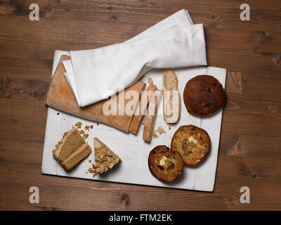 Various breads & cake on a chopping board