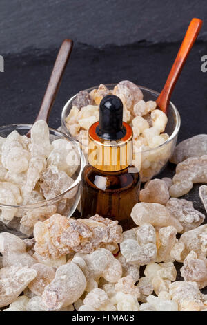 A bottle of myrrh essential oil with myrrh resin on a dark background Stock  Photo - Alamy