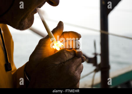 Fisherman lighting cigarette - trawling the coast of Santa Catarina Stock Photo