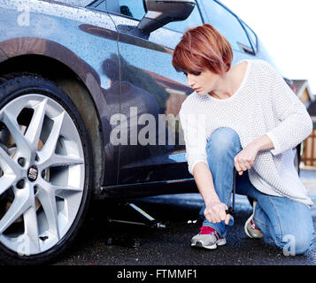 Woman changing wheel on her car Stock Photo
