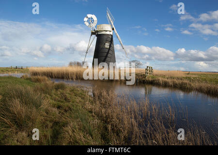 Mutton's Drainage Mill stands on the edge of a waterway at Halvergate Marshes along the Norfolk Broads, East Anglia, England, UK Stock Photo