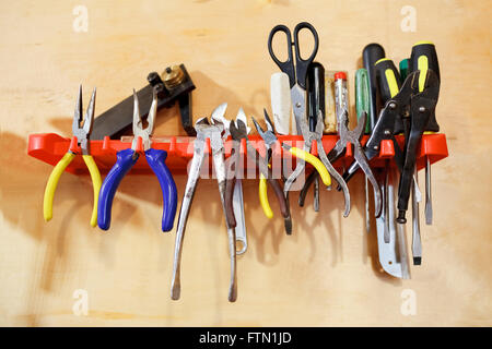 Workshop tools pliers on wall stand. Stock Photo