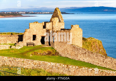 Fragment of ruins of Dunluce castle in County Antrim, Northern Ireland, UK, with the far view of  Portrush resort Stock Photo