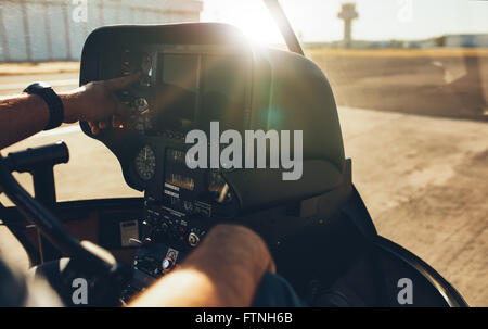 Close up shot of pilot checking the gauges on the instrument panel dashboard of  a helicopter with bright sunlight. Stock Photo