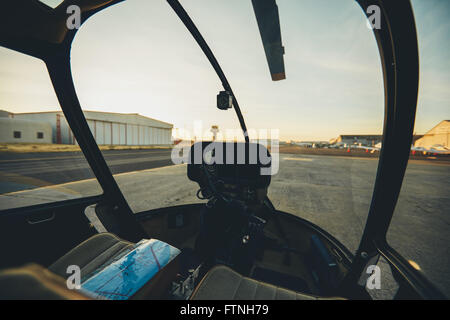 Inside view of a helicopter cockpit with instrument panel dashboard. Helicopter parked at airport. Stock Photo