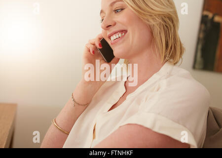 Close up of a happy woman talking on mobile phone. Caucasian female in conversation on cellphone. Stock Photo