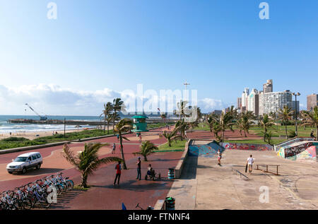 Many unknown people enjoy and early morning visit to beach front in Durban South Africa Stock Photo