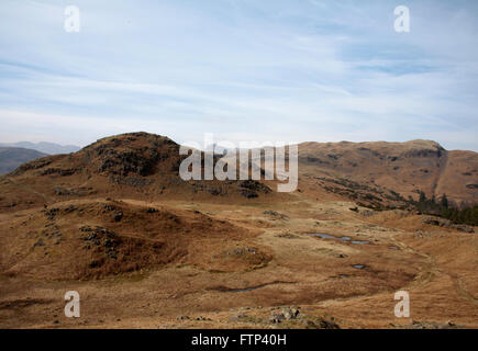 The distant Langdale Pikes viewed from  near Dow Bank above Grasmere Lake District Cumbria England Stock Photo