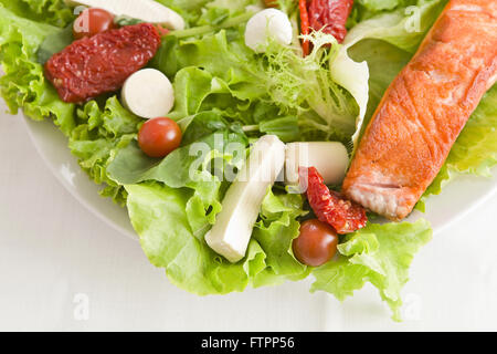 File de salmao grelhado e salada de tomate seco e palmito Stock Photo