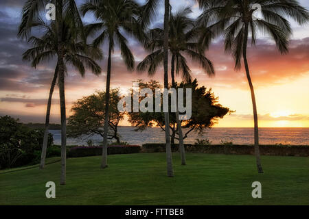 The setting sun illuminates the sky over Turtle Cove at Hapuna Beach on the Big Island of Hawaii. Stock Photo
