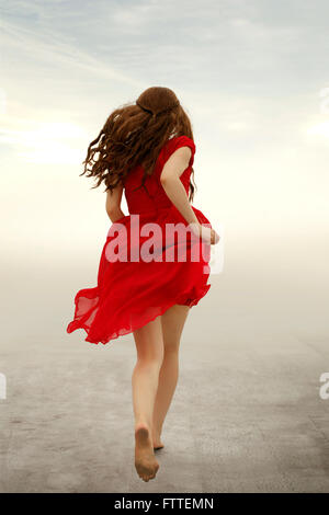 Woman in red dress running away