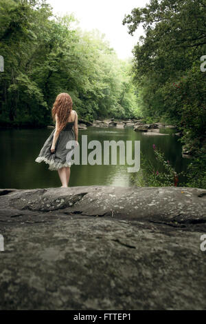 Woman in long sun dress at lake