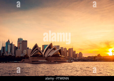 Sydney, Australia - November 11, 2015:  Opera House with Sydney city bihind at sunset. View from the ferry. Stock Photo