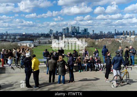 Visitors to Greenwich look out across the park towards the Queen's House, Old Royal Naval College and Canary Wharf Stock Photo