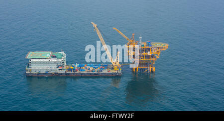 Aerial shot of oil rig and barge during installation phase Stock Photo