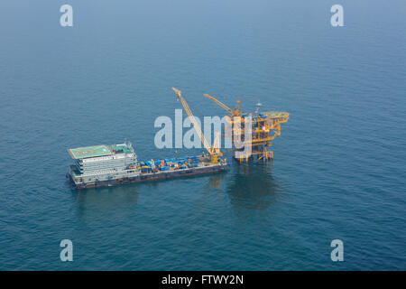 Aerial shot of oil rig and barge during installation phase Stock Photo