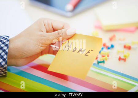 Human hand holding adhesive note with Home text Stock Photo