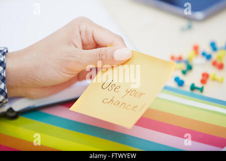 Human hand holding adhesive note with Use your chance text Stock Photo