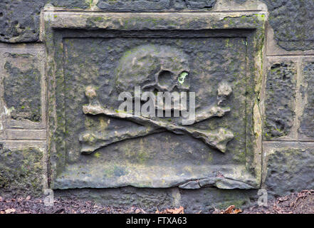 A close-up of a skull on a headstone in a graveyard. Stock Photo