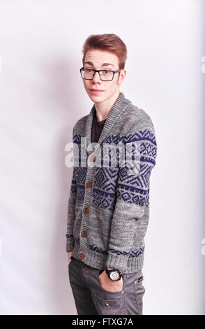 Young man with glasses on standing straight with his hands in his pockets looking straight ahead Stock Photo