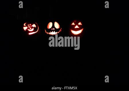 Halloween Jack-o-lantern pumpkins glowing in dark Stock Photo