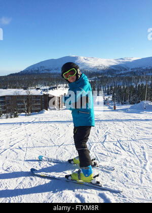 Boy standing on piste in ski wear Stock Photo