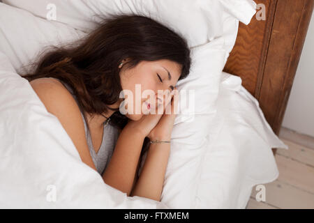 Teenage girl sleeping in bed Stock Photo