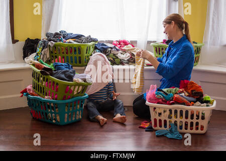 Mother and young boy folding clothes and laughing together Stock Photo