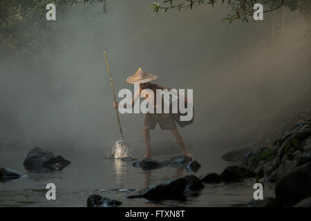 Young boy fishing with a spear, Nong Khai, Thailand Stock Photo