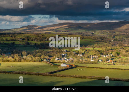 Panoramic landscape, rolling hills and cloudy sky. View from hill top,long shadows at sunset. Stock Photo