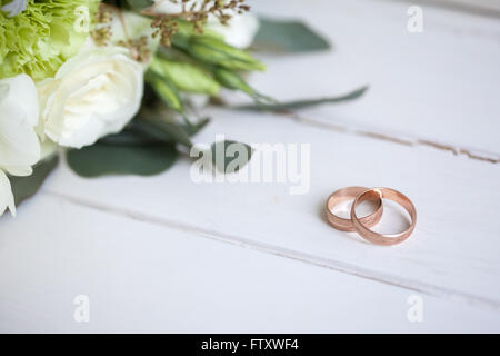 The wedding rings with white roses Stock Photo