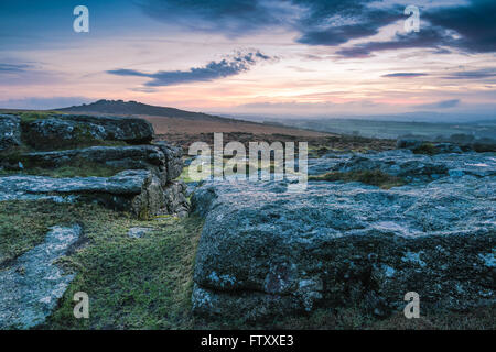 Cloudy and dramatic sky over granite rocks and hills in Dartmoor Park, UK Stock Photo