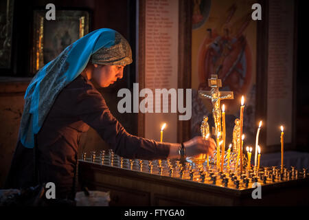 Kazakhstan, Kazakistan, Asia, a veiled woman with candles in orthodox church. Stock Photo