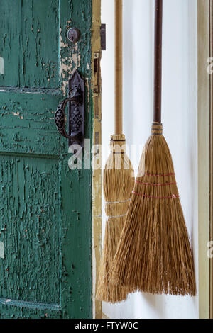 Broom and old door in traditional Shaker house. Stock Photo