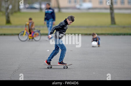 Bad Fallingbostel, Germany. 30th Mar, 2016. A refugee child rides a skateboard at the site of the Camp Bad Fallingbostel Ost refugee accommodation in Bad Fallingbostel, Germany, 30 March 2016. Around 850 are currently being housed in Camp Ost. Photo: HOLGER HOLLEMANN/dpa/Alamy Live News Stock Photo